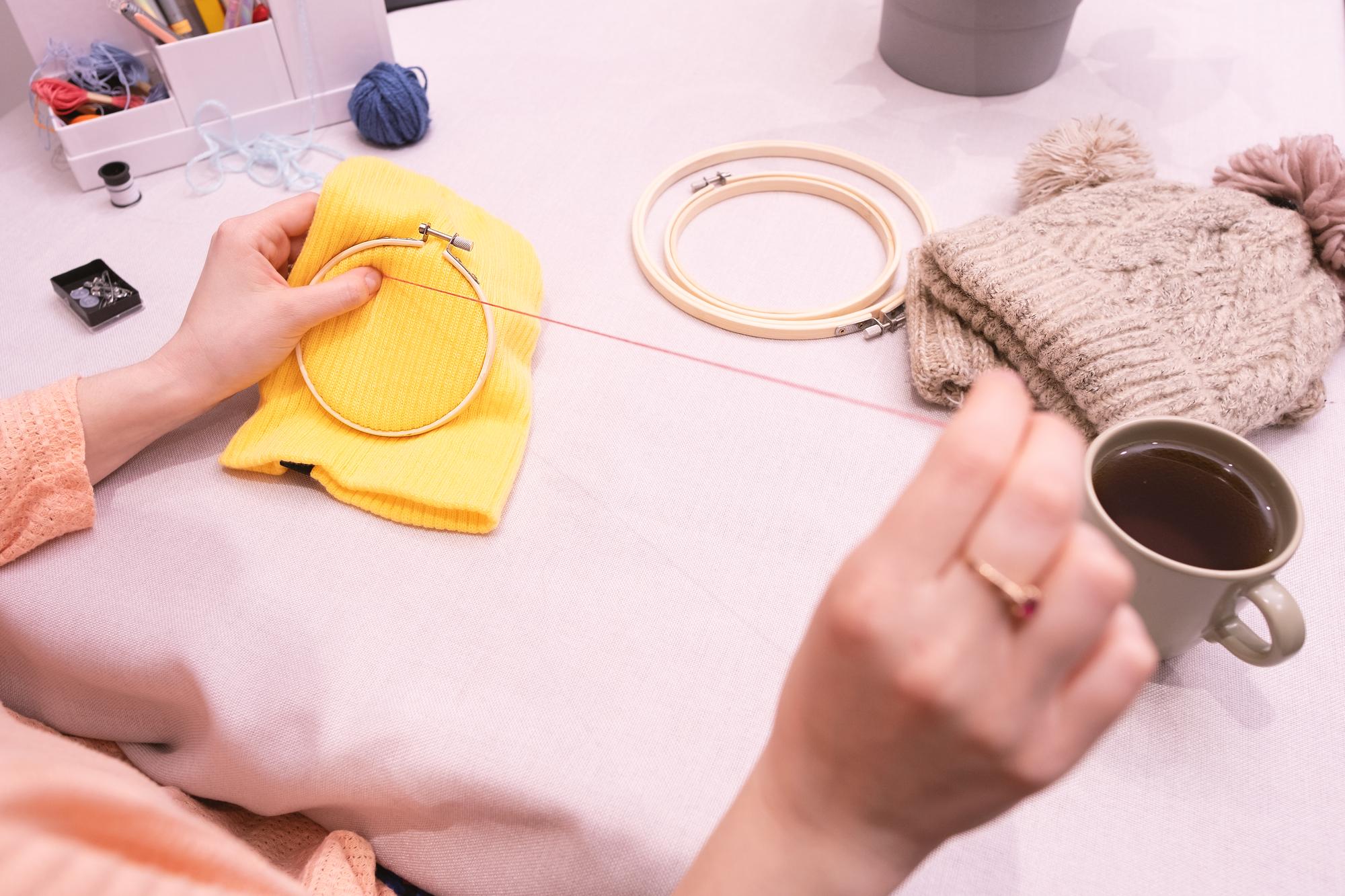 Student at home working on hoop with threads