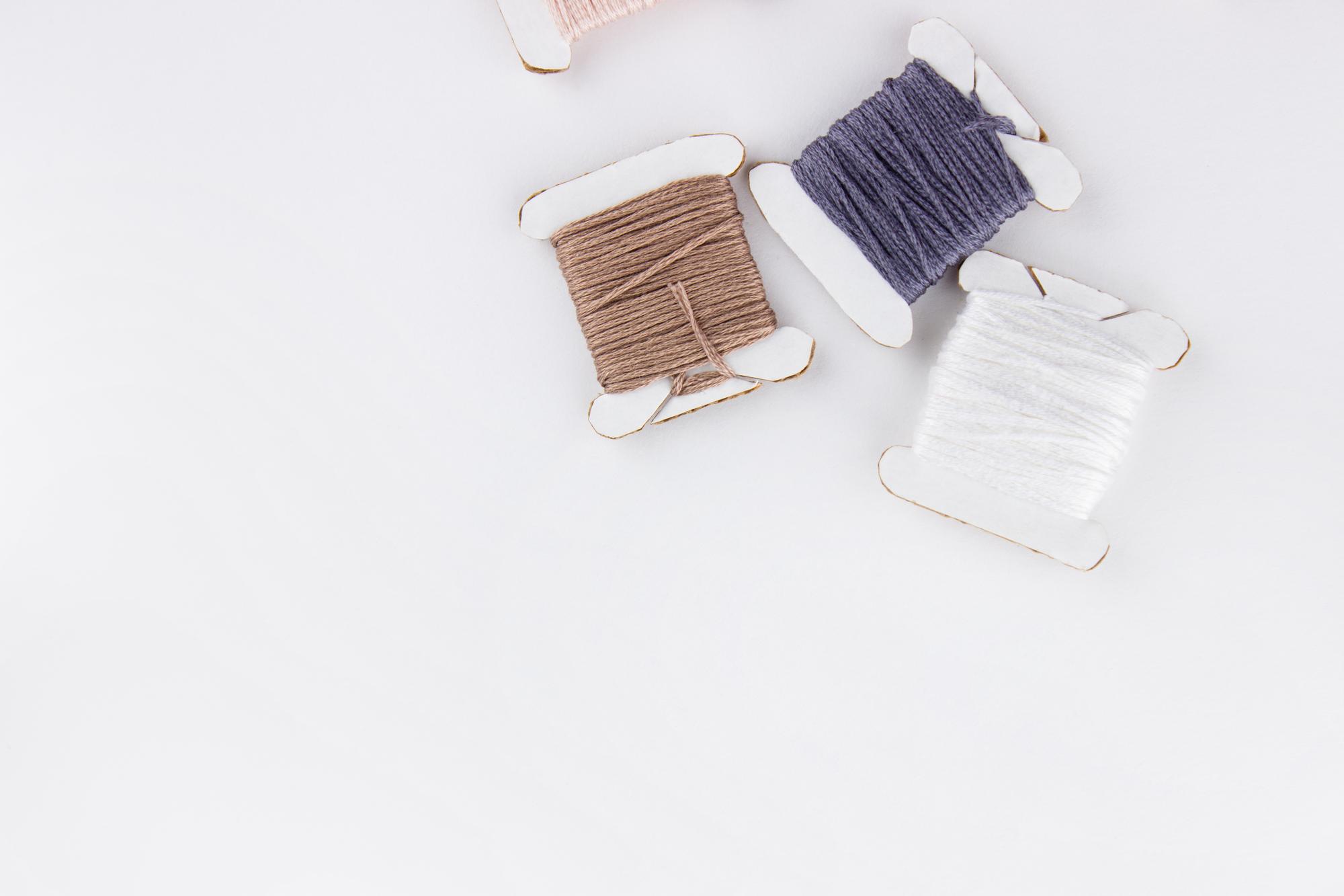 Set of needles and linen samples on wooden table